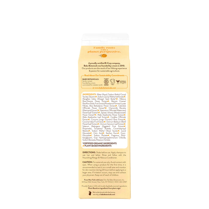 The image features a beige carton with orange accents, showcasing Babo Botanicals Nourishing Shampoo for Dry, Damaged Hair. Black text highlights organic ingredients like mango butter and details sustainable commitments alongside cautionary notes.