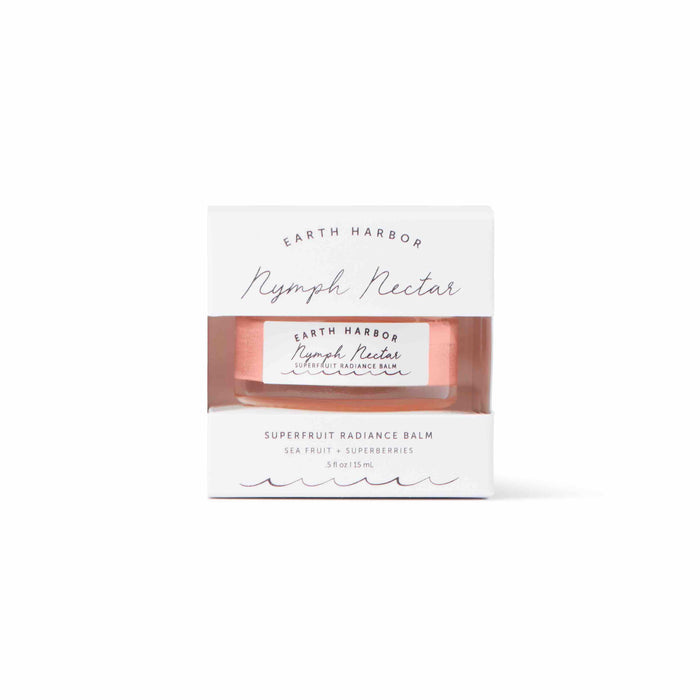 A white box with a cutout showcases a 15 ml jar labeled NYMPH NECTAR Superfruit Radiance Balm by Earth Harbor. This luxurious sleeping mask, infused with sea fruit and superberries, features a vegan, wax-free formula in minimal design packaging with elegant fonts.