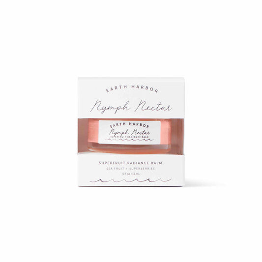 A white box with a cutout showcases a 15 ml jar labeled NYMPH NECTAR Superfruit Radiance Balm by Earth Harbor. This luxurious sleeping mask, infused with sea fruit and superberries, features a vegan, wax-free formula in minimal design packaging with elegant fonts.