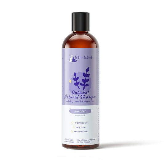 A 12 oz bottle of kin+kind Oatmeal Shampoo for dogs and cats with lavender oil. The cruelty-free label features purple designs with icons for vet-formulated, easy rinse, and extra moisture pet soap. Made in the USA.