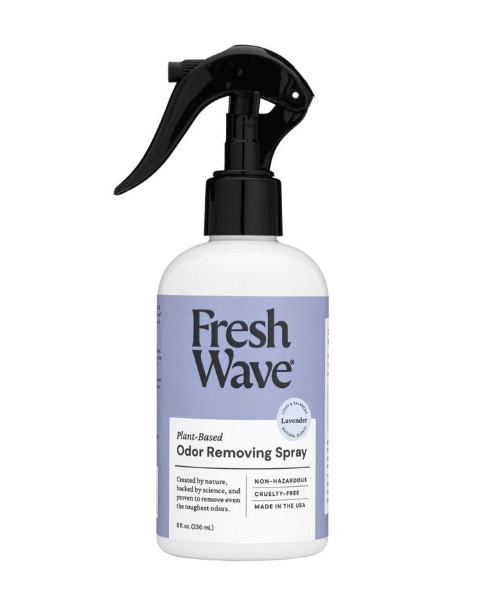 A Fresh Wave Odor Removing Fabric and Linen Spray: a white bottle with a purple label and black trigger nozzle. This USA-made, lavender-scented, plant-based spray is non-hazardous, cruelty-free, and ideal for refreshing fabrics and rooms.