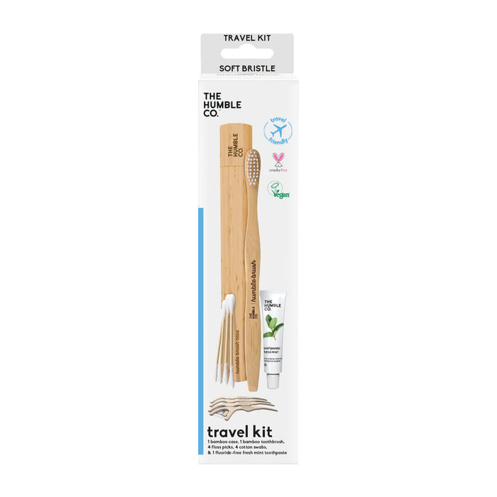 The Oral-Care Travel Kit from The Humble Co. highlights a bamboo toothbrush, toothpaste, and plant-based floss picks in eco-friendly packaging. Adorned with vegan and cruelty-free icons, the box uses recycled materials and prominently features Soft Bristle at the top.