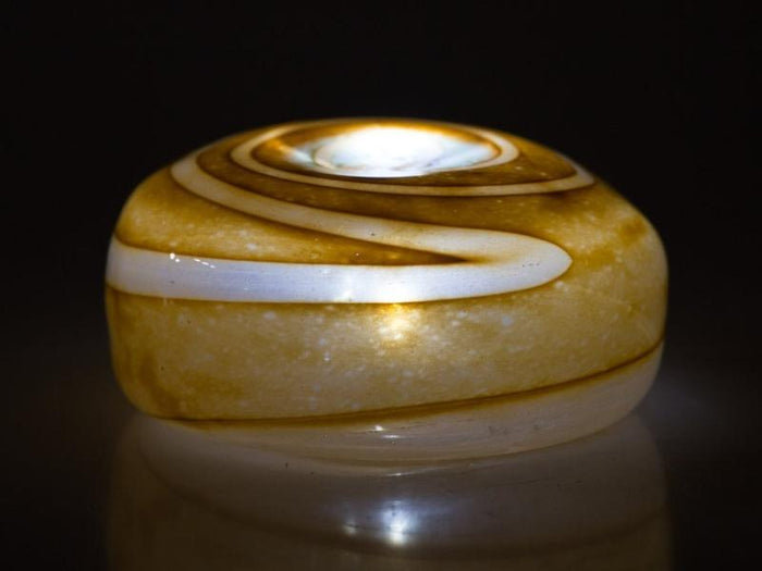 Orange tan hollow votive stone with white speckled interior and central opening for a tealight