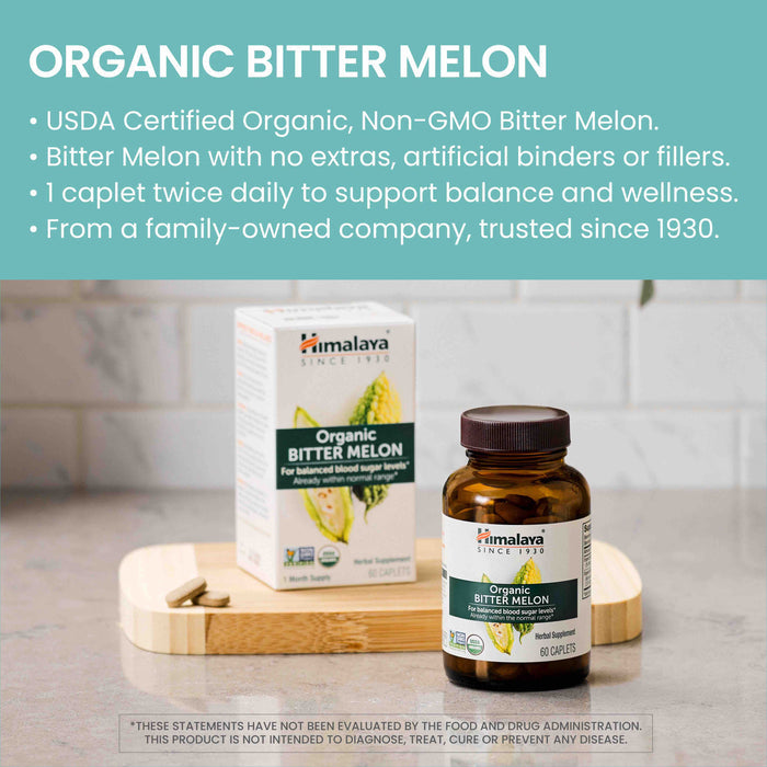 Image of a box and bottle of "Himalaya Organic Bitter Melon" dietary supplement on a grey surface. The box and bottle are labeled with information highlighting that it is USDA Certified Organic, Non-GMO, and intended to support balanced blood sugar levels.
