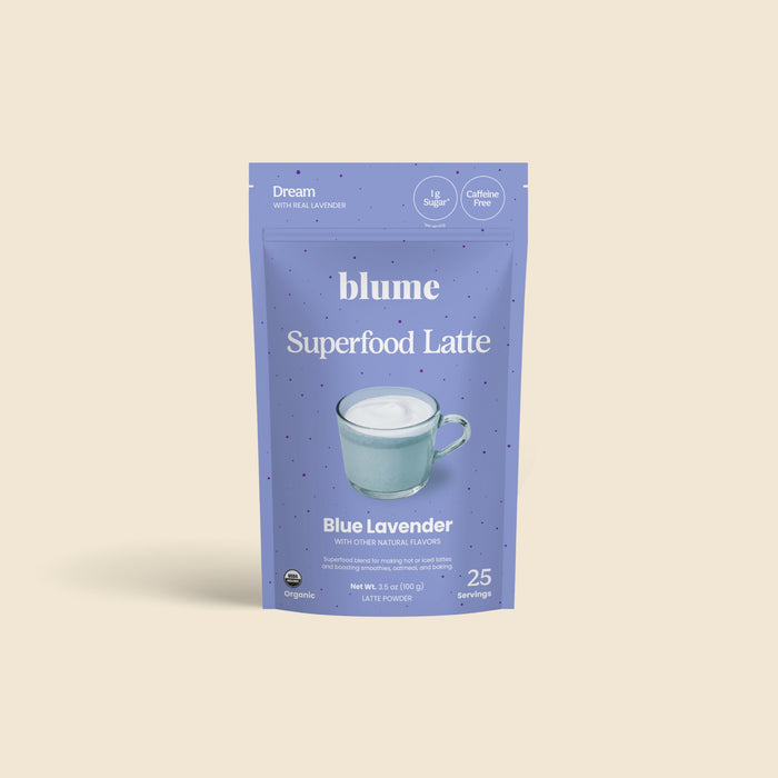 An upright pouch of blume Organic Blue Lavender Latte Powder is shown, featuring a cup of foamy latte and highlighting that this calming bedtime drink is caffeine-free, organic, and offers 25 servings.