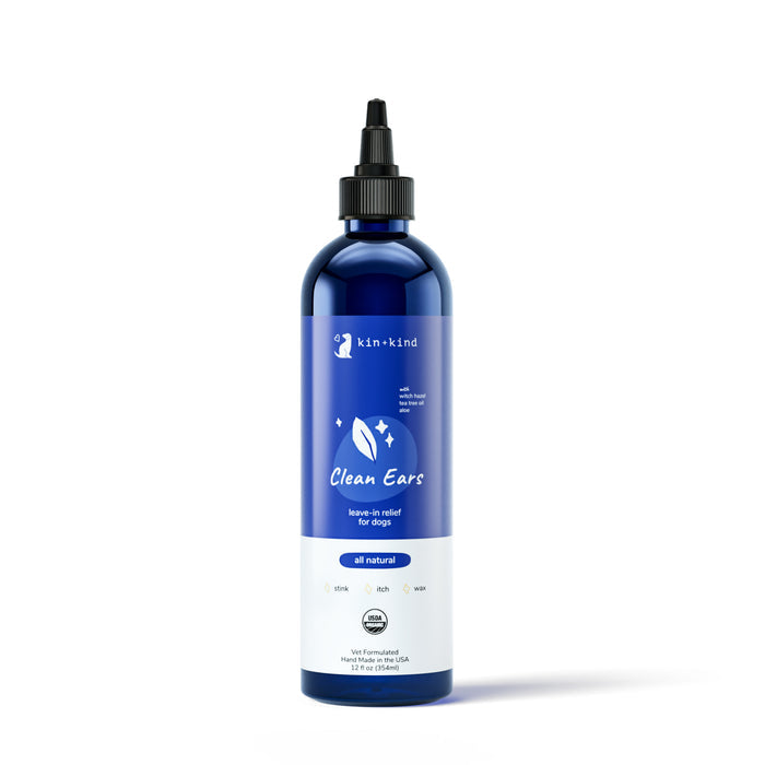 The 12 fl oz Organic Clean Ears by kin+kind is a USDA organic certified, all-natural leave-in dog ear cleaner. It comes in a blue bottle with a black nozzle and features leaf and star icons on its white label.