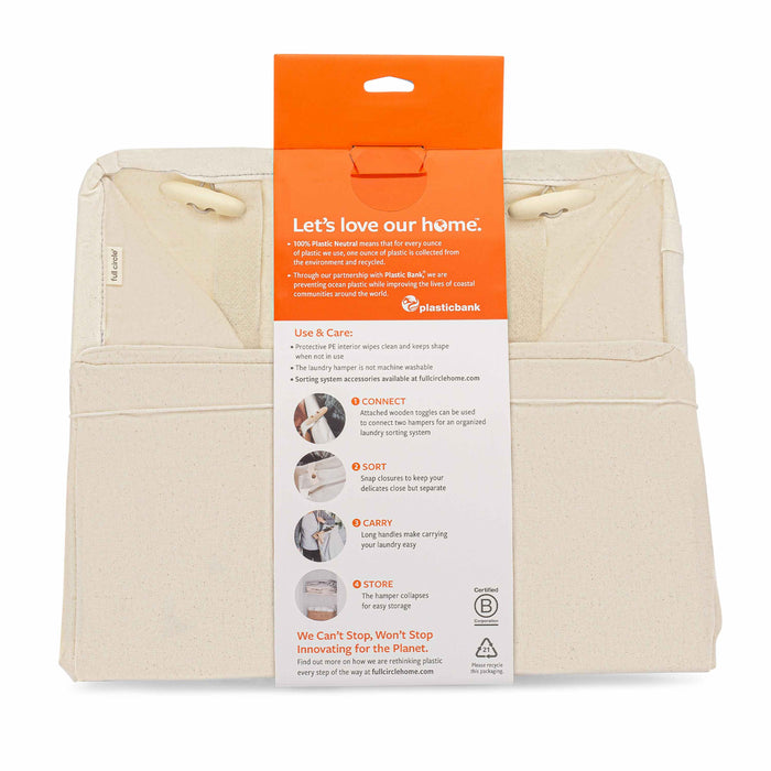 Image of a beige Organic Cotton Laundry Hamper by Full Circle with an orange tag, Lets love our home. It features connectivity, detachable parts, and easy storage. Promoting sustainability and innovation with Plastic Bank, this hamper simplifies laundry sorting.