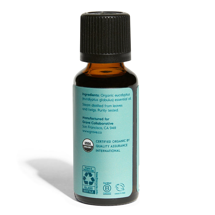 A small amber glass bottle with a black cap features a turquoise label for Grove Co.s Organic Eucalyptus Essential Oil - Stimulating Aromatherapy. It details certified organic ingredients, USDA Organic and recycling logos, certifications, and manufacturer info.