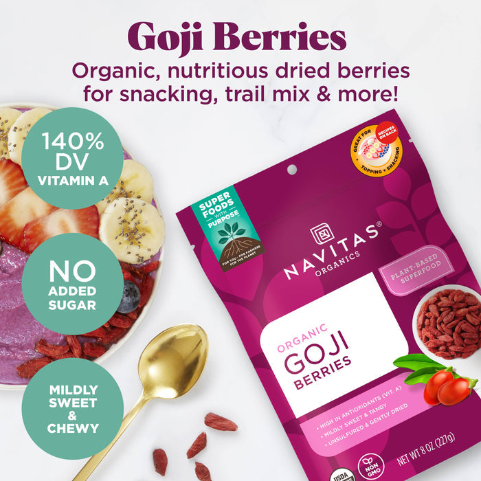 Package of Navitas Organics Goji Berries with scattered berries and a spoon. A bowl of fruit in the background. Text highlights benefits: 140% DV Vitamin A, no added sugar, mildly sweet and chewy. Superfoods label.