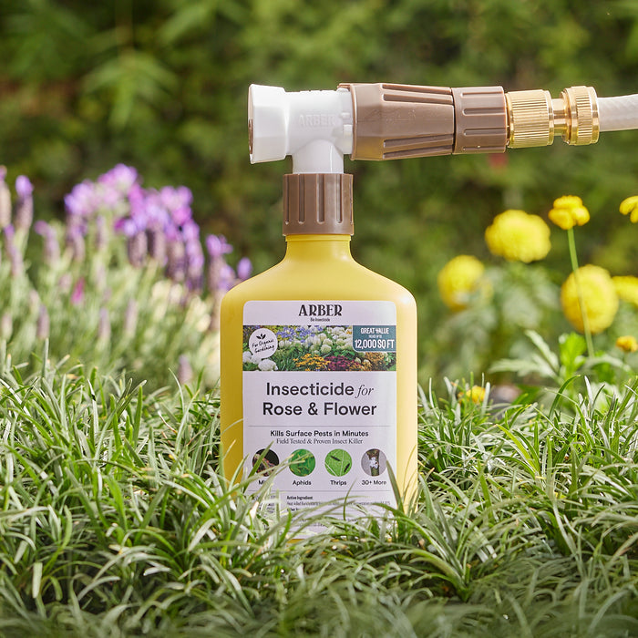 A bottle of Arbers Organic Insecticide for Rose and Flowers RTS, equipped with a garden hose attachment, sits among lush plants and vibrant blooms. The flourishing garden backdrop boasts purple and yellow flowers, offering an effective solution for outdoor pests.