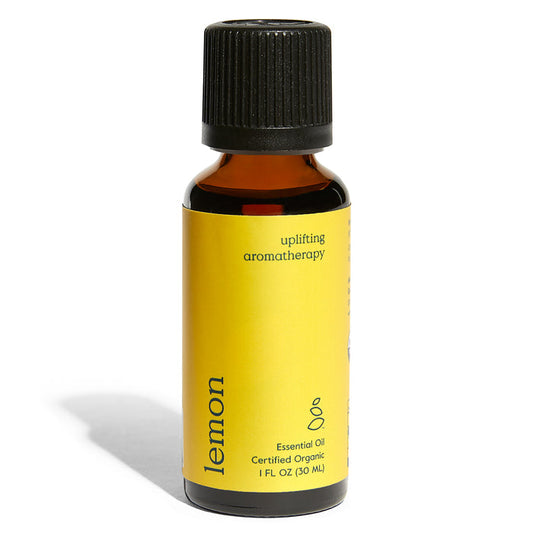 Grove Co.s Organic Lemon Essential Oil comes in a small amber 1 fl oz (30 ml) bottle with a black cap, featuring a yellow label marked uplifting aromatherapy and Certified Organic, ideal for space enhancement through its purifying properties.