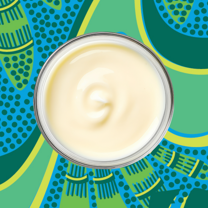 A glass bowl of smooth white yogurt sits on a vibrant, abstract background—perfect for blending with Kuli Kuli Foods Organic Moringa Green Smoothie + Protein to whip up a nourishing superfood energy shake.