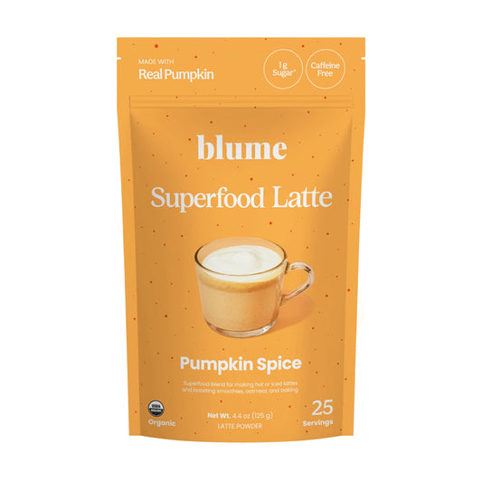 An orange bag labeled blume Organic Pumpkin Spice Latte Powder with a latte image. This superfood powder uses real organic pumpkin, has only 1g sugar, is caffeine free, and makes 25 servings.