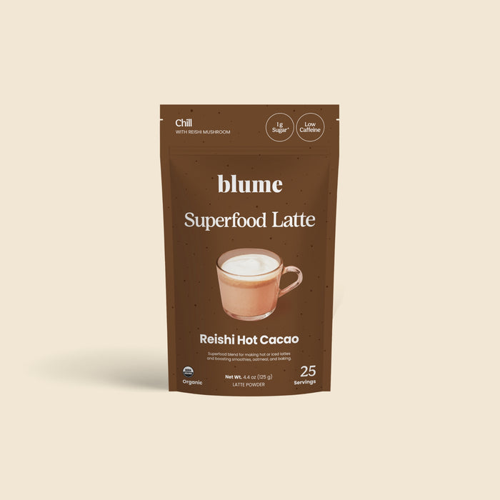 A brown pouch of blume Organic Reishi Hot Cacao Latte Powder features a mug of foamy hot chocolate on the packaging, highlights adaptogen ingredients, and offers 25 servings per bag.