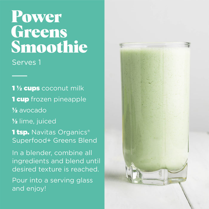 A glass of light green smoothie is on a wooden surface. The recipe on the left details ingredients: coconut milk, frozen pineapple, avocado, lime juice, and greens blend. Instructions include blending and serving. "Power Greens Smoothie" serves one.