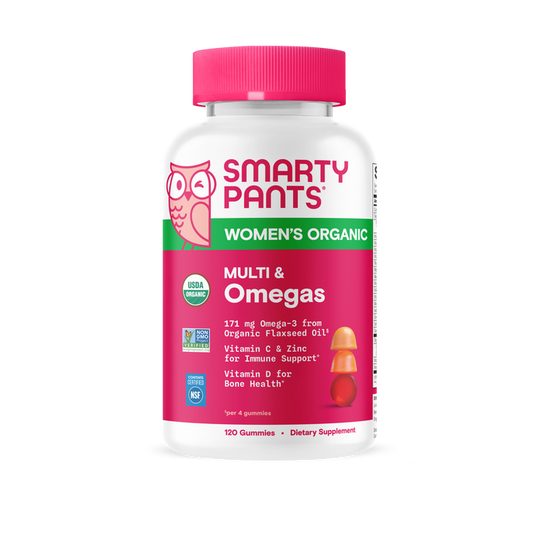 A bottle of SmartyPants Organic Women’s Multi & Omegas Gummies features a pink cap and label emphasizing Omega-3, vitamin C, zinc, and vitamin D3. This organic women’s multivitamin provides 120 vegetarian gummies per bottle, delivering essential nutrients in a tasty omega-3 gummy form.