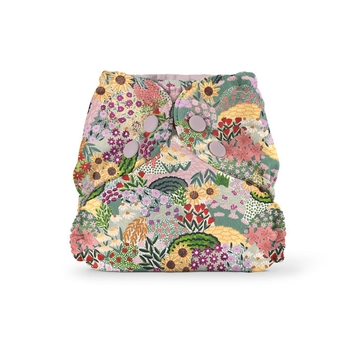 The Esembly Baby Outer Diaper Cover + Swim Diaper, Size 2, features a colorful floral pattern with lush greenery, made from 100% OEKO-TEX Certified Recycled Fabric and secured with metal snaps for a snug, eco-friendly fit.