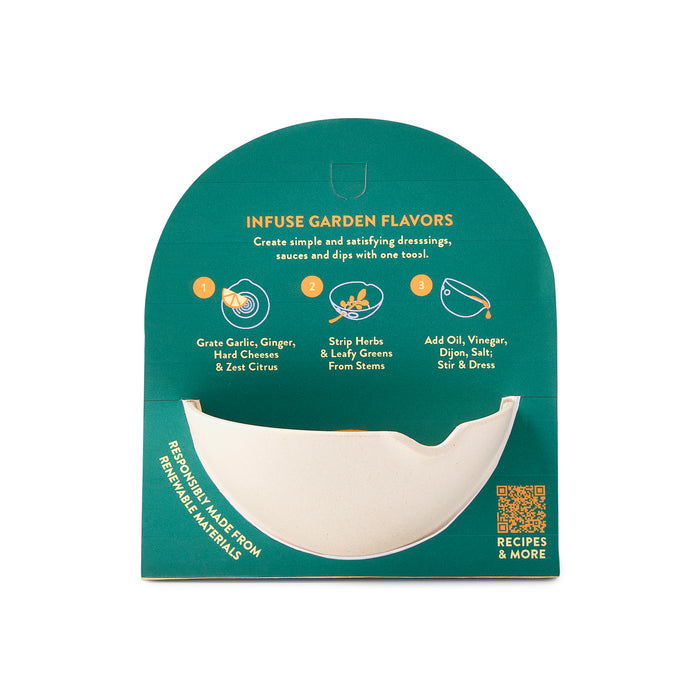 Modern Sprouts Peel, Grate & Prep Dish packaging showcases a half-bowl-shaped kitchen tool with an integrated grater for herbs and ingredients like oil and vinegar. The teal package includes illustrations, a QR code for recipes, and is crafted from sustainable materials for versatile culinary use.