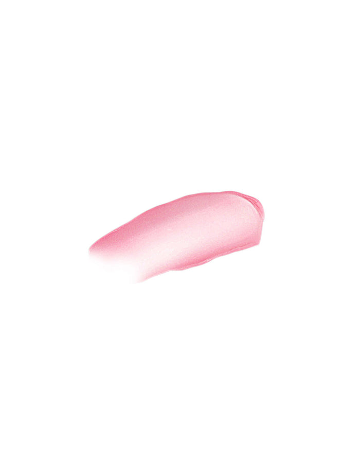 A swatch of Kari Gran Peppermint Lip Whip Treatment Balm reveals a smooth, glossy texture. The gradient shifts from darker to lighter pink on a plain white background, highlighting its quality as an organic lip balm.