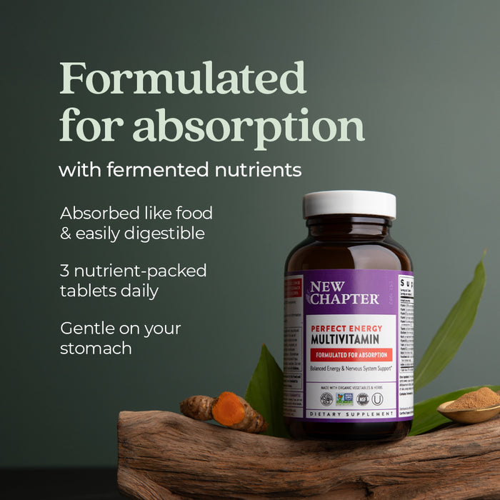 A bottle of New Chapter Perfect Energy™ Multivitamin with Vitamin B12, B6, and D3 sits on wood with turmeric and a green leaf. Text highlights energy support, fermented nutrients for absorption, easy digestion, 3 tablets daily, gentle on stomach.