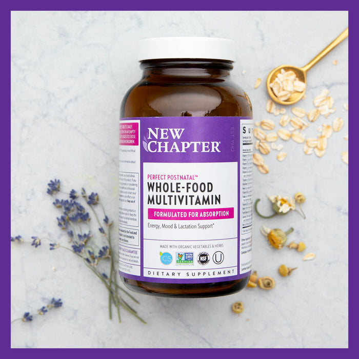 A bottle of New Chapters Perfect Postnatal™ Multivitamin sits on a marble surface with dried flowers and oats, highlighting its benefits of energy enhancement, mood balance, and lactation support in an optimally absorbent formula.
