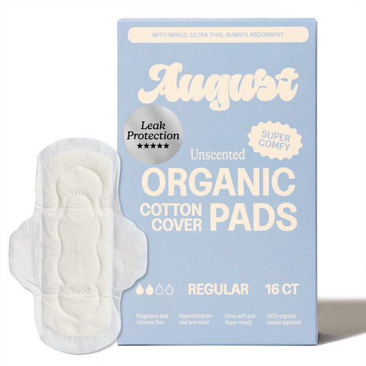 A box of August Night Pads, which are hypoallergenic with an organic cotton cover, is shown beside an individual pad. The pastel blue box highlights leak protection, super comfort, and regular absorbency features.