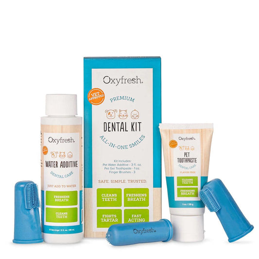 The Oxyfresh Pet Dental Kit contains a water additive, pet dental gel toothpaste, and two blue rubber finger brushes. Its packaging highlights benefits such as cleaning teeth, freshening breath, and fighting tartar for effective dental care.