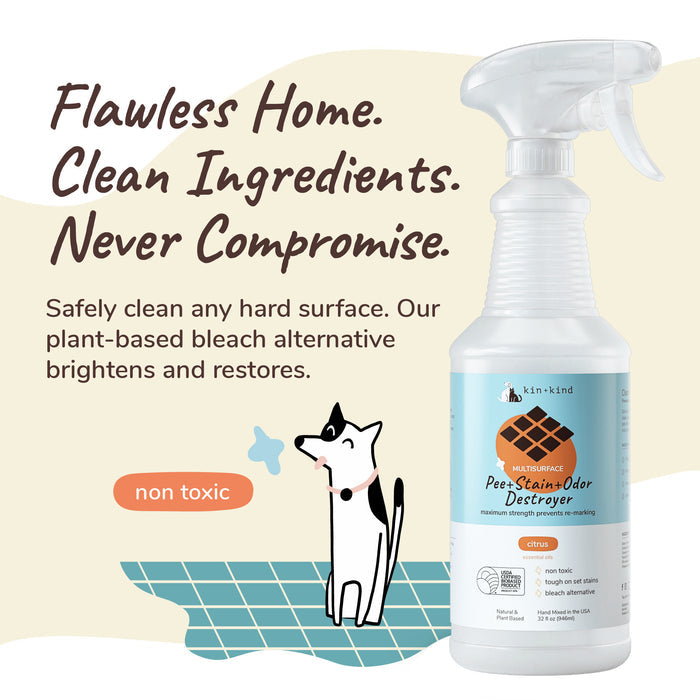 The kin+kind Pet Pee + Stain + Odor Remover Multi-Surface Spray with a cartoon dog on a green grid background promotes Flawless Home. Clean Ingredients. Never Compromise. It uses naturally derived zinc salt as a non-toxic bleach alternative, ensuring pet safety.