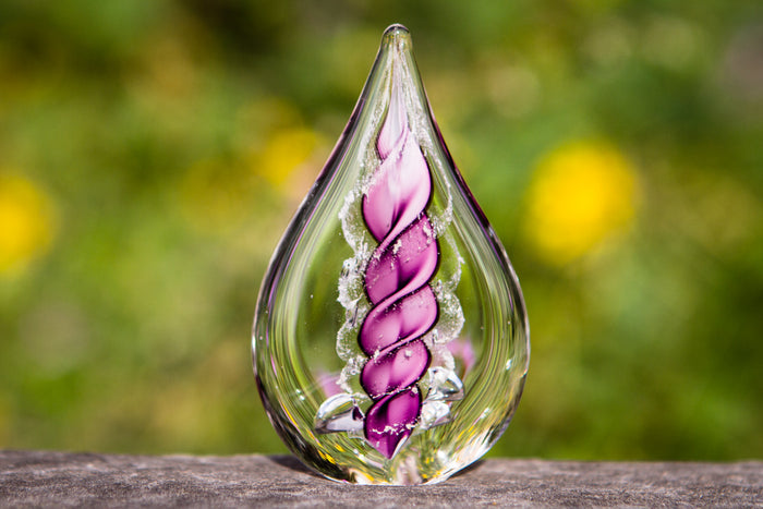 Petite memorial glass flame infused with cremation ashes, purple spiral design inside clear glass.