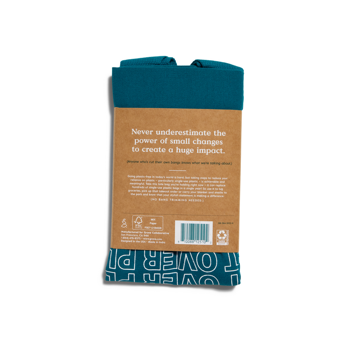 A folded teal ‘Planet Over Plastic’ Reusable Tote Bag from Grove Co. features a label with the quote Never underestimate the power of small changes to create a huge impact, detailed text, a barcode, and motivational white text promoting reusable bags for a plastic-free future.