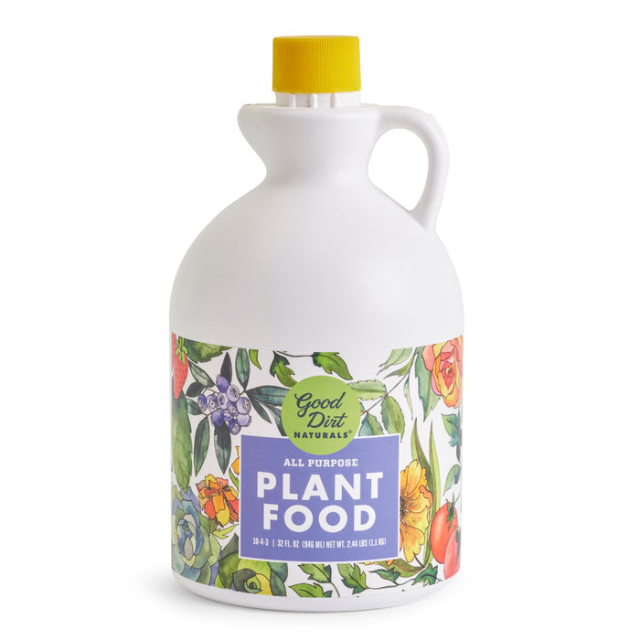 A white plastic jug labeled Good Dirt Plant Food has a yellow cap and colorful flower illustrations. The container houses sustainable plant food with a 10-4-3 nutrient ratio, promoting garden vitality.