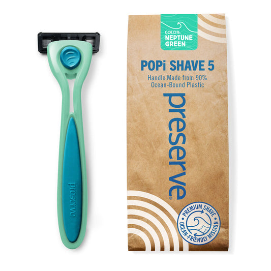 A Preserve Recycled Ocean Plastic (POPi) Shave 5 Razor System in Neptune Green is shown alongside its brown packaging, which highlights that it is a sustainable razor made from 90% ocean-bound plastic.