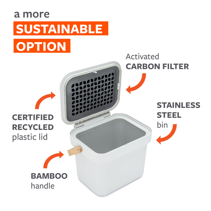 An open compost bin with a certified recycled plastic lid, bamboo handle, and stainless steel body. The lid contains an activated carbon filter. Text reads: "A more sustainable option.