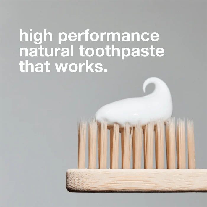 A wooden toothbrush with white Davids Premium Toothpaste - Whitening + Antiplaque is shown close-up against a plain background. Text above reads, “high performance natural whitening toothpaste that works.”.