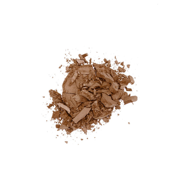 The Lily Lolo Pressed Bronzer, a blend of natural minerals, is shown crushed and scattered on a white background, resembling a broken makeup compact—ideal for achieving a sun-kissed glow.
