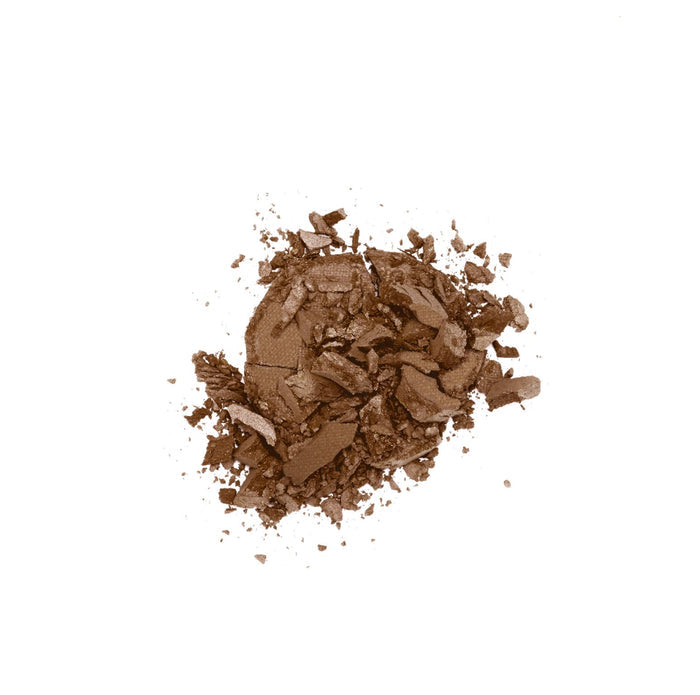 A pile of Lily Lolos Pressed Bronzer, rich with natural minerals, sits on a white background. The unevenly scattered brown powder features visible chunks and smaller specks, resembling a sun-kissed glow.
