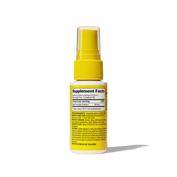 A yellow spray bottle, labeled Propolis Immune Support Throat Spray by Beekeepers Naturals, shows supplement facts and casts a shadow on a white background. The white label lists ingredients and warns to keep out of childrens reach, indicating its use as an immunity booster with bee propolis.