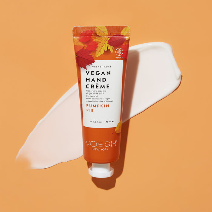 The Pumpkin Pie Duo with Nail Stickers by VOESH New York sits on a soft orange background, surrounded by a smear of white cream and autumn leaf designs, perfectly capturing the essence of the season.