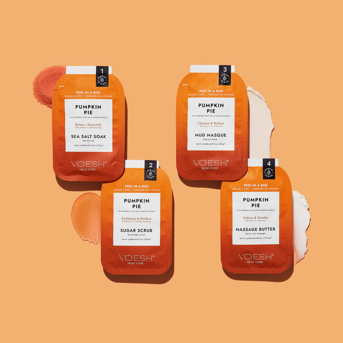 Two orange VOESH Pumpkin Pie Duo with Nail Stickers packets are displayed on a peach background with soft paint-like swatches, evoking the cozy autumn scent of pumpkin pie.