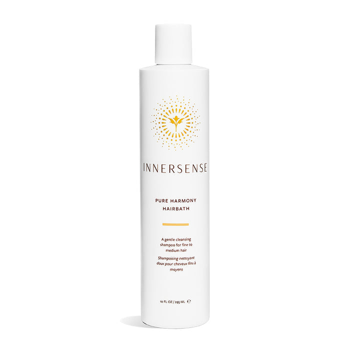 Innersense Organic Beautys Pure Harmony Hairbath comes in a white cylindrical bottle with a yellow geometric label. This gentle, sulfate-free shampoo is designed for fine to medium hair and contains an organic blend. The bottle holds 10 fl oz (295 mL).