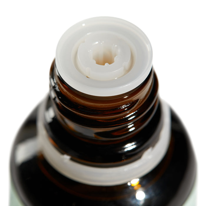 Close-up of Grove Co.s Purify Essential Oil Blend - Peppermint & Eucalyptus in an open brown glass bottle with a ridged neck and white cap rim, highlighting its design for aromatherapy and home fragrance. The reflective surface accentuates its use.