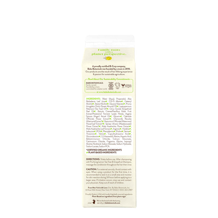 The back of a Babo Botanicals Purifying Conditioner for Flat, Oily Hair bottle reveals text on its grapefruit and lemon-scented tea tree oil-infused ingredients, usage directions, and sustainability commitments, highlighting family roots and eco-friendly practices for a sustainable routine.