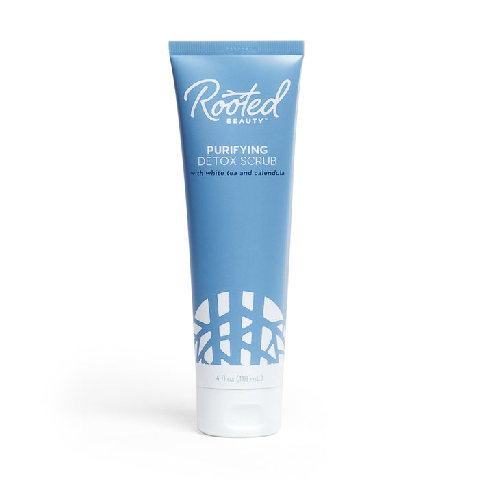 A 4 fl oz (118 ml) blue tube of Rooted Beauty Purifying Detox Scrub with white tea, calendula, and walnut shell powder for gentle exfoliation. It has a white cap, decorative pattern at the bottom, is EWG VERIFIED™, and features white text.