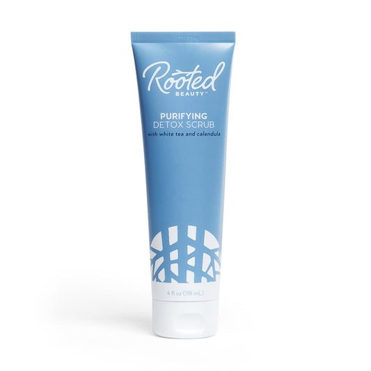 A 4 fl oz (118 ml) blue tube of Rooted Beauty Purifying Detox Scrub with white tea, calendula, and walnut shell powder for gentle exfoliation. It has a white cap, decorative pattern at the bottom, is EWG VERIFIED™, and features white text.