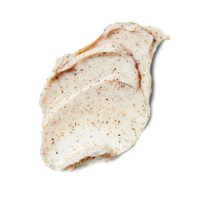 A dollop of cream-colored Rooted Beautys Purifying Detox Scrub, enriched with walnut shell powder for gentle exfoliation, spread across a white surface.