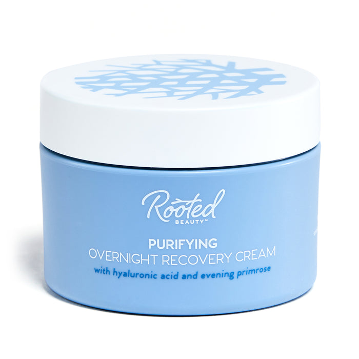 A blue jar of Rooted Beauty Purifying Overnight Recovery Cream contains R7 Complex, hyaluronic acid, and evening primrose. It features a white lid with an abstract flower-like pattern.
