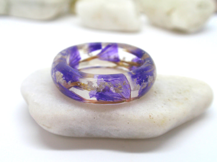 Angled view of purple flower cremation ash ring in clear resin