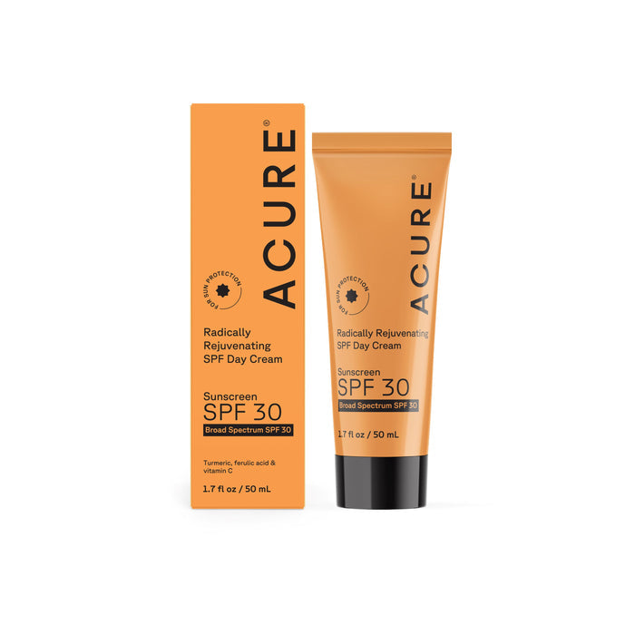 A tube and box of Acure Radically Rejuvenating Day Cream - SPF 30 (1.7 fl oz, 50 mL) in orange packaging. This broad-spectrum sunscreen features zinc oxide, turmeric, ferulic acid, vitamin C, and nourishing botanicals.