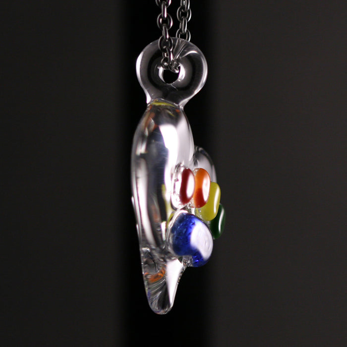 Side view of a clear Rainbow Bridge pawprint pendant with colorful beads inside on a chain