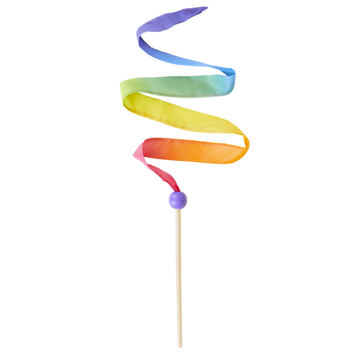 Sarahs Silks Rainbow Streamer features a wooden stick with a purple bead and a vibrant silk ribbon in shades of purple, blue, green, yellow, and red. It spirals gracefully to create a cheerful pattern perfect for open-ended play.